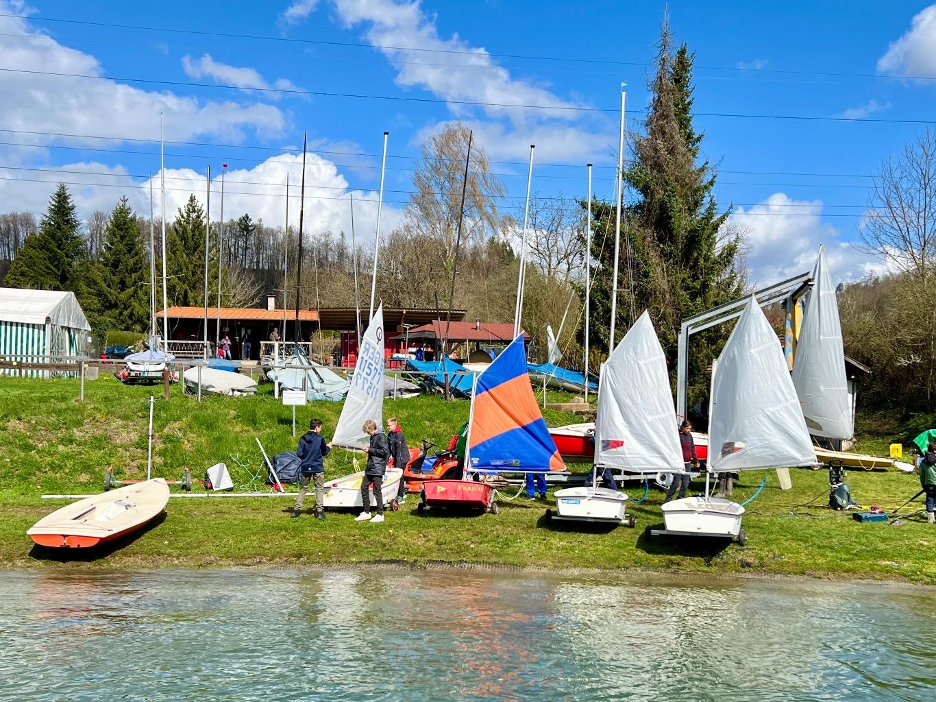 Kleine Segelboote, Optis, mit Kindern am Ufer